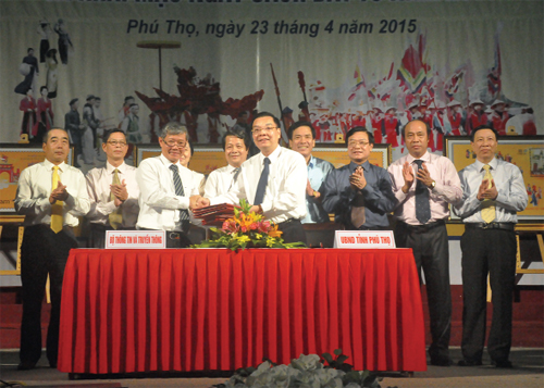 Các đại biểu chứng kiến lãnh đạo Bộ Thông tin và Truyền thông và UBND tỉnh Phú Thọ ký tên, đóng dấu ngày phát hành đầu tiên bộ tem vào bìa phát hành đặc biệt.
